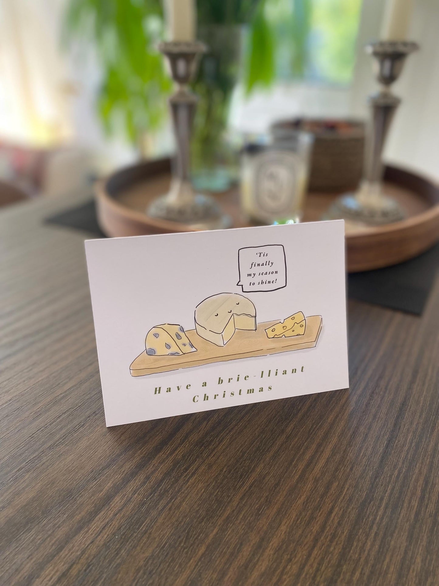 Card with cheese illustration and text on a wooden table