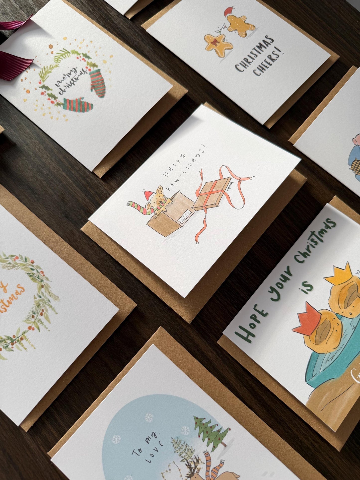 Collection of Christmas cards with various designs on a wooden surface