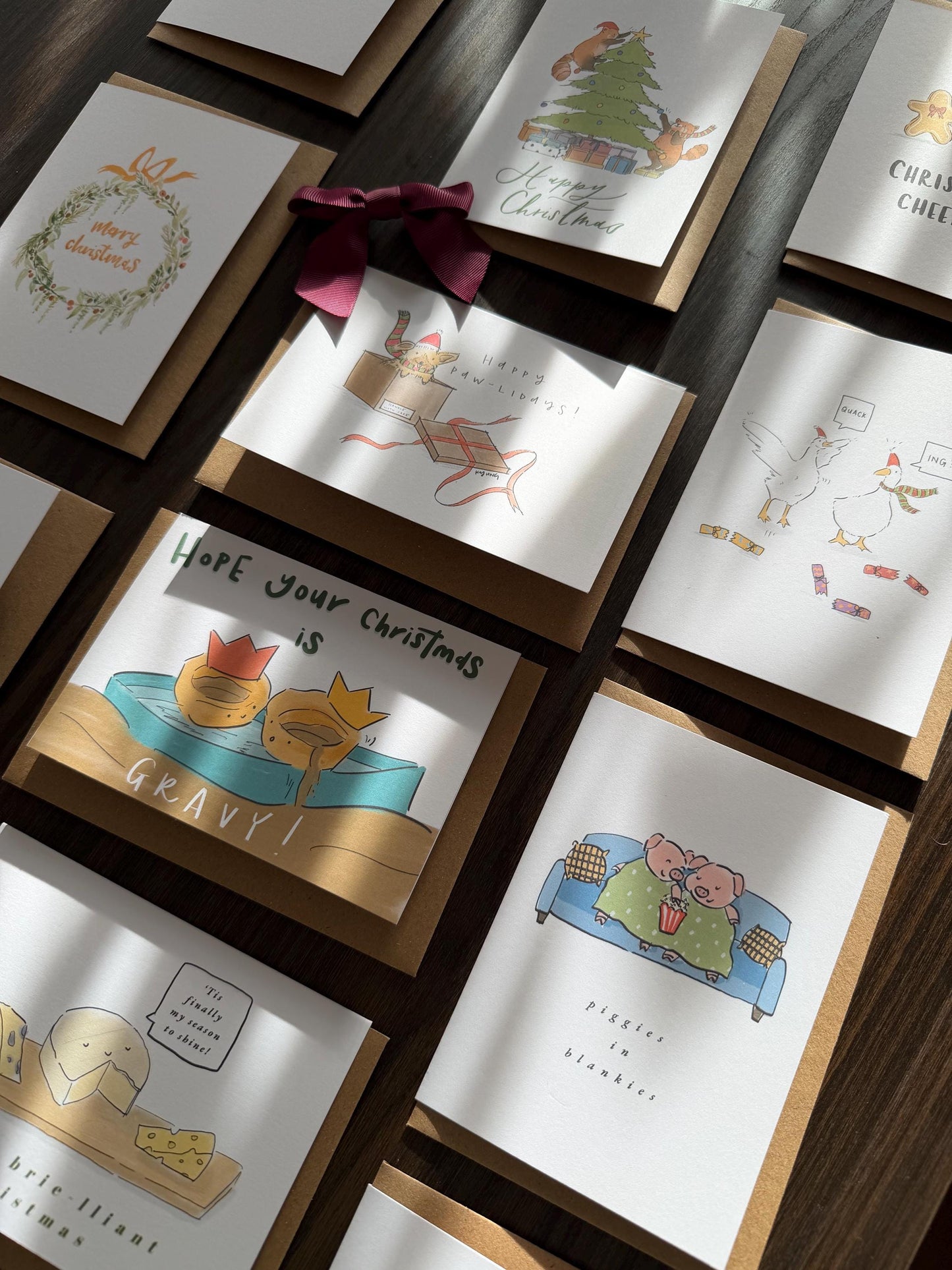 Collection of Christmas-themed greeting cards on a wooden surface.