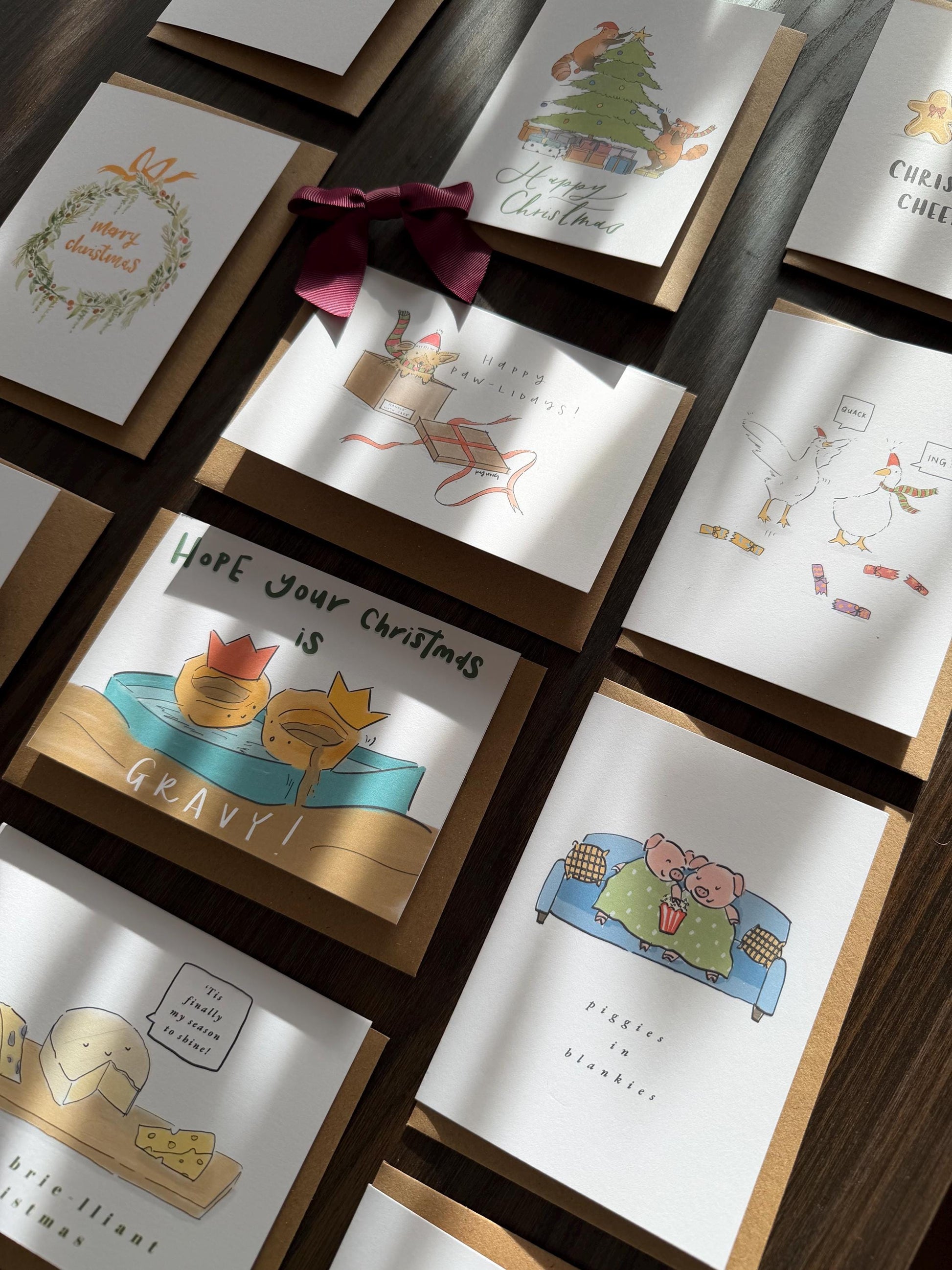Collection of Christmas-themed greeting cards on a wooden surface.