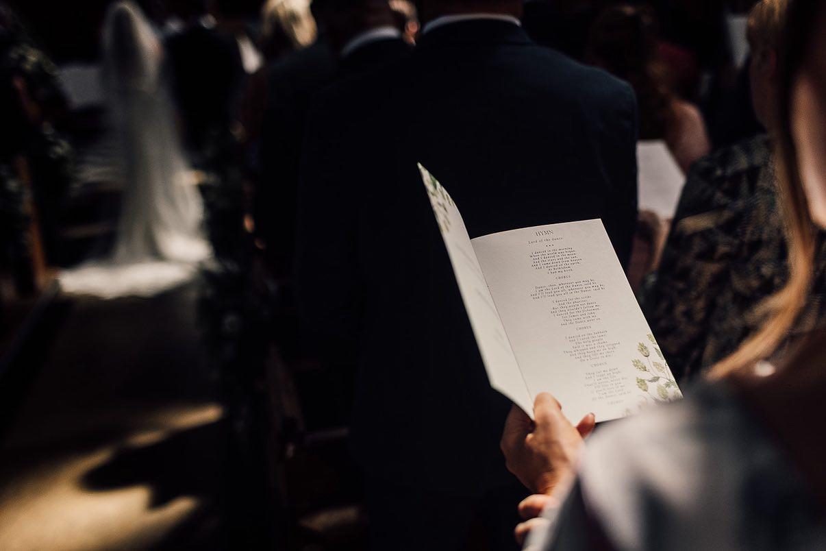 Person holding a wedding program at a ceremony