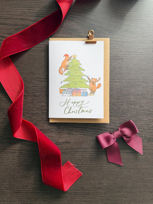 Christmas card with festive design, red ribbon, and bow on a wooden surface