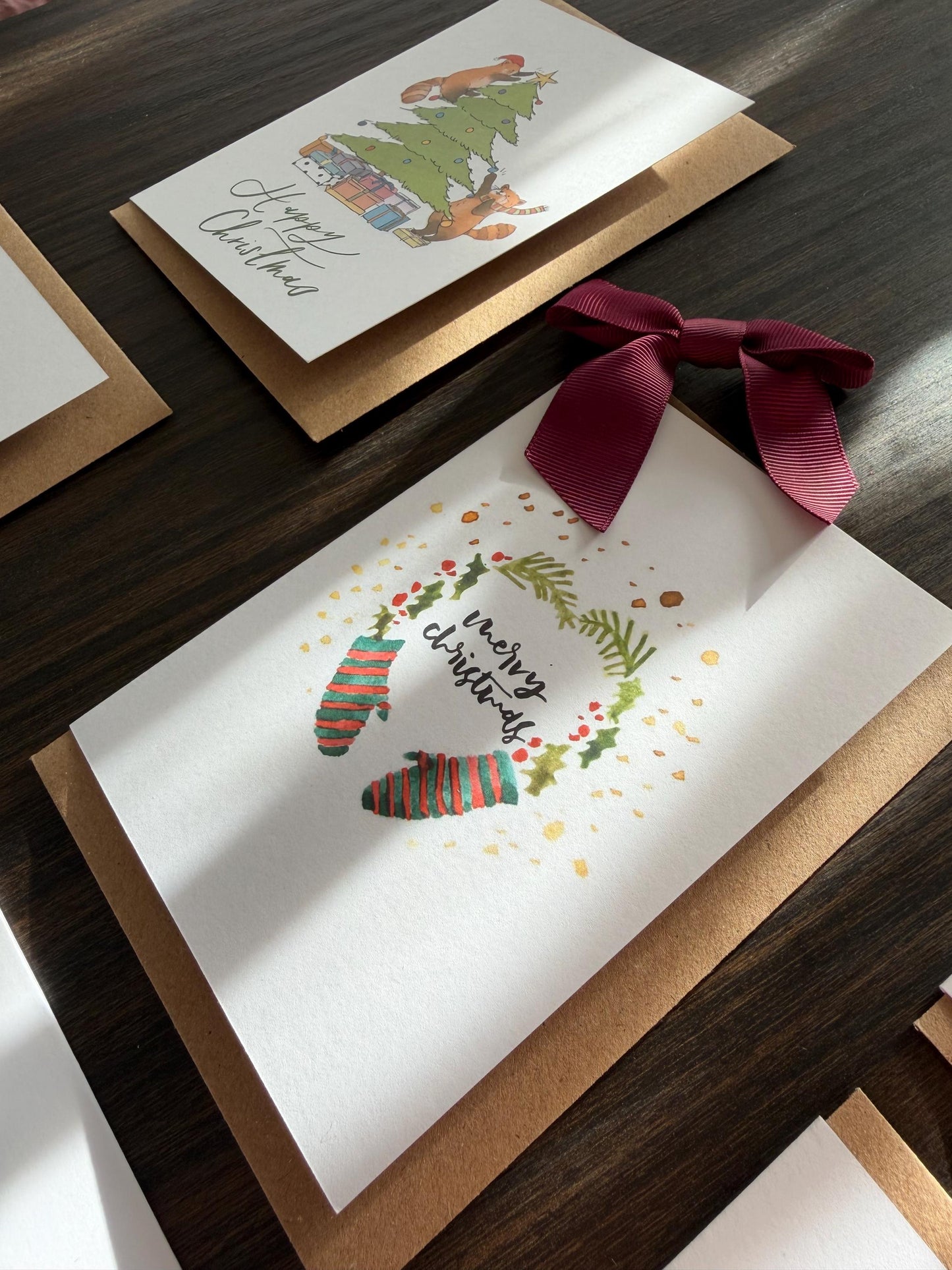 Christmas-themed greeting card with stockings and wreath on a wooden surface