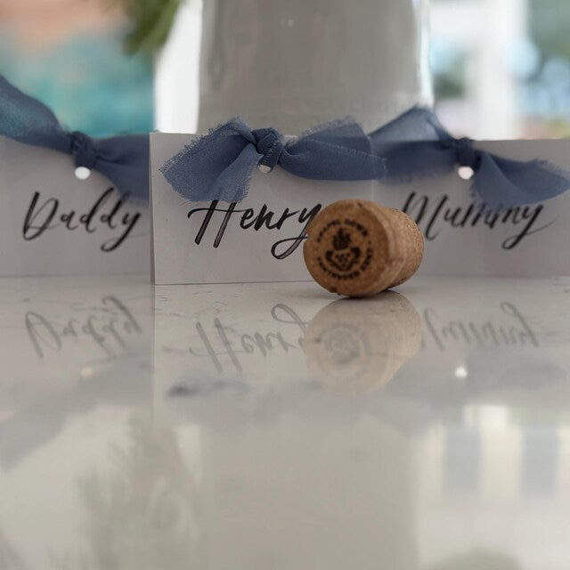 Cork with personalized name cards on a reflective surface