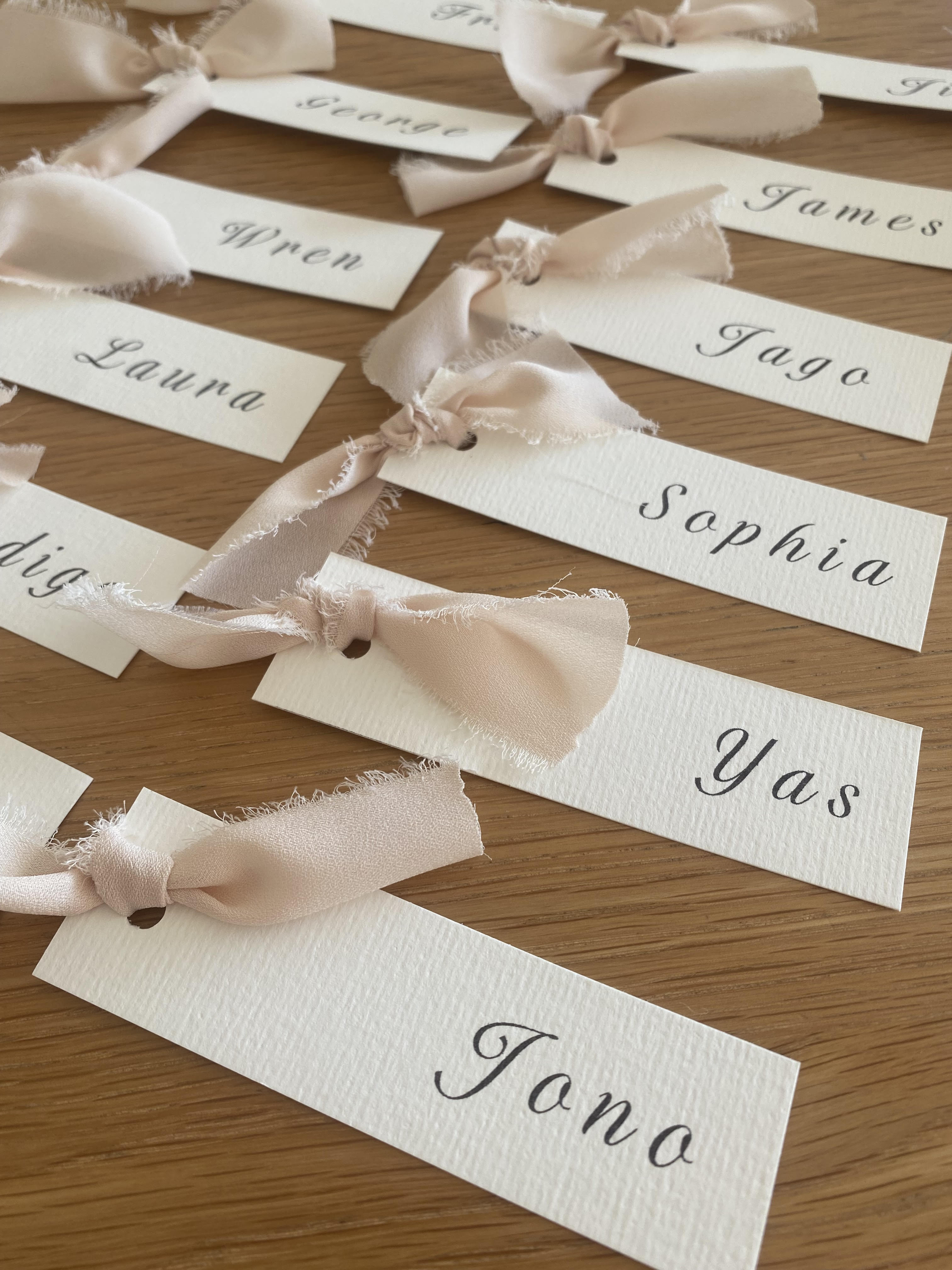 Place cards with ribbons on a wooden surface